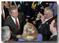 President George W. Bush wades into a crowd of handshakes and flashing cameras as he welcomes mayors and county official to the East Room Jan. 24. White House photo by Tina Hager.