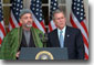 President George W. Bush listens to Chairman of the Afghan Interim Authority Hamid Karzai during their joint press conference in the Rose Garden, January 28. "Chairman Karzai is a determined leader, and his government reflects the hopes of all Afghans for a new and better future; a future free from terror, free from war, and free from want," said the President. White House photo by Eric Draper