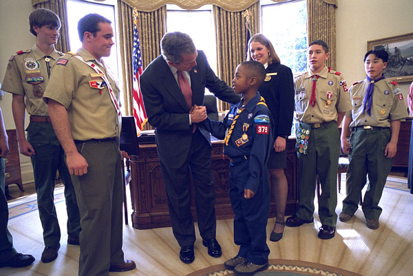 President George W. Bush talks with Jordon Wade, 9, of Pittsburgh during the presentation of the annual report by the Boy Scouts of America in the Oval Office Feb. 12, 2002. Other scouts included in the ceremony are, from left to right, Joe Honious, 16, of Dayton, Ohio; Clay Capp, 18, of Nashville, Tenn.; national Venturing President Marissa Morgan, 19, of Winston-Salem, NC; Joshua Cudd, 12, of Conroe, Texas; and Ryan Iwata, 12, of San Francisco. Not pictured is David Richey, 18, of Seattle, Wash. White House photo Eric Draper.