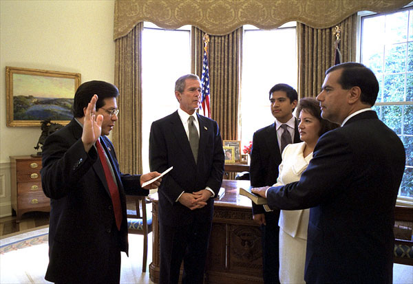 President George W. Bush watches as White House Counsel Albert Gonzales swears in Gaddi H. Vasquez as the 16th Peace Corps director in the Oval Office Feb. 14. Standing with Mr. Vasquez is his wife, Elaine, and son, Jason. White House photo by Eric Draper.