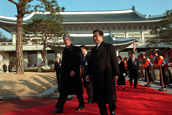 President George W. Bush and President Kim Dae-Jung proceed through an arrival ceremony at The Blue House in Seoul, Republic of Korea, Feb. 20. "I understand how important this relationship is to our country, and the United States is strongly committed to the security of South Korea. We'll honor our commitments. Make no mistake about it that we stand firm behind peace in the Peninsula." White House photo by Paul Morse.