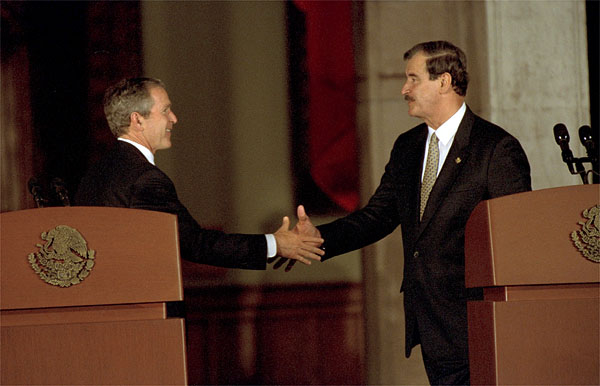 President George W. Bush reaches for Mexico's President Vicente Fox during a joint press conference at the Palacio de Gobierno in Monterey, Mexico, Friday, March 22. "The relationship between the United States and Mexico is very strong, is very important, and it's growing stronger every day," said President Bush in his remarks. White House photo by Eric Draper.
