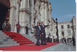 President George W. Bush and Peruvian president Alejandro Toledo (right) wave from the steps of the Presidential Palace in Lima, Peru, March 23, 2002. "It is an honor for me to be the first sitting President of the United States to visit Peru," said President Bush during the two leaders' joint press conference where he explained that steps such as reintroducing the Peace Corps to Peru are being taken to strengthen the relationship between America and Peru.
