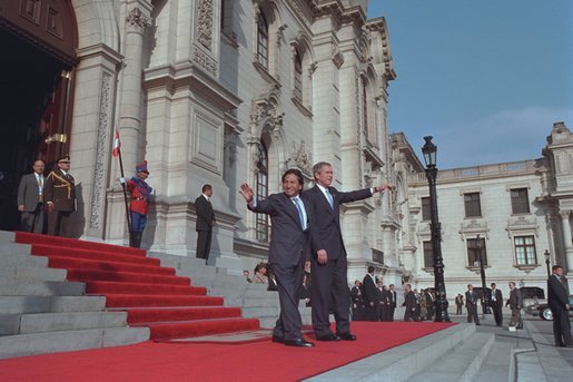 President George W. Bush and Peruvian president Alejandro Toledo (right) wave from the steps of the Presidential Palace in Lima, Peru, March 23, 2002. "It is an honor for me to be the first sitting President of the United States to visit Peru," said President Bush during the two leaders' joint press conference where he explained that steps such as reintroducing the Peace Corps to Peru are being taken to strengthen the relationship between America and Peru.