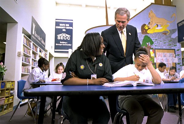 President George W. Bush talks with students at the South End Community Center in Bridgeport, Conn., Tuesday, April, 9. Americorps volunteers come to the community center to mentor students. "We need to encourage programs to expand, to give people an outlet, a chance to participate," said the President during his remarks at the city's Klein Auditorium where he oulined how people could join the ranks of thousands who are already serving in one America's Freedom Corps groups. White House photo by Tina Hager.