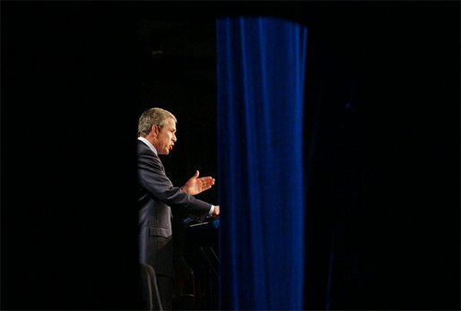 Photographed through stage curtains, President George W. Bush delivers his remarks on compassionate Conservatism at Parkside Hall in San Jose, Ca., Tuesday, April 30. White House photo by Eric Draper.