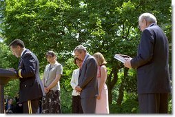 Led by Army Chaplain David Hicks, President George W. Bush prays with the family and friend of two recipients of the medal of honor during posthumous ceremony in the Rose Garden May 1, 2002. Captain Ben Salomon and Captain Jon Swanson were awarded the medal of honor for acts of bravery during World War II and the Vietnam War. Pictured with the President are Sandra Swanson (center) and her daughters Brigid Jones (left) and Holly Walker and Dr. Robert West, who received the honor on the behalf of Captain Ben Salomon. White House photo by Tina Hager.