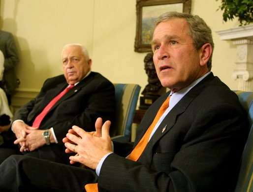 President George W. Bush answers questions from the press with Israeli Prime Minister Ariel Sharon in the Oval Office on Tuesday afternoon. White House photo by Paul Morse.
