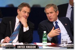 President George W. Bush chats with British Prime Minister Tony Blair during the meeting of the NATO-Russia Council at Practica di Mare Air Force base near Rome, Italy on May 28, 2002 White House photo by Paul Morse.