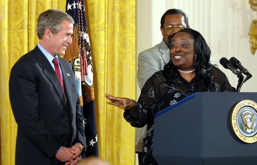 President George W. Bush receives praise from Welfare to Work graduate Ann Briscoe and her husband Alfred at an East Room event at the White House on June 4, 2002. White House photo by Paul Morse.