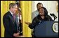 President George W. Bush receives praise from Welfare to Work graduate Ann Briscoe and her husband Alfred at an East Room event at the White House on June 4, 2002.  
