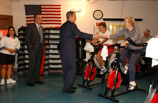 Accompanied by the Governor of Florida, his brother Jeb Bush, President George W. Bush visits senior citizens participating in an aerobic "spinning class" at the Marks street Senior Recreation Complex in Orlando, Fla., Friday, June 21, 2002. 