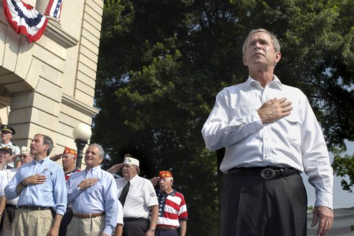 President George W. Bush joins war veterans on stage during the Pledge of Allegiance to open the 