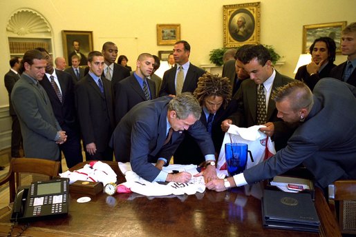 President Bush signs a team jersey for the U.S. Soccer Team in the Oval Office Friday, August 2, 2002. White House photo by Eric Draper.