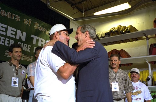 President George W. Bush embraces rescued coal miner John Unger at the Green Tree Fire Department in Green Tree, Pa., Monday, Aug. 5. Pulled from a collapsed mine in Somerset, Pa., nine miners survived three days in a flooded mine shaft before rescuers found them. Also pictured are, from left to right, miners Mark Popernack, Randy Fogle and Tom Foy. White House photo by Paul Morse. White House photo by Paul Morse.