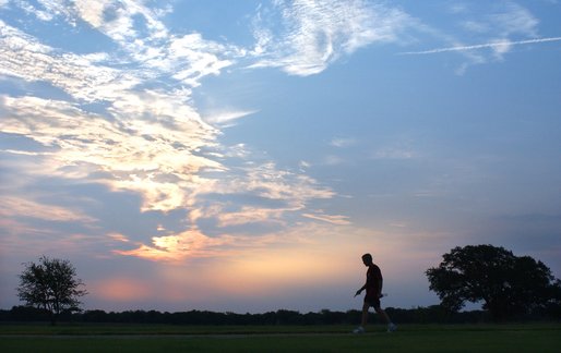 President George W. Bush is silhouetted against an early morning sky after a run at his ranch in Crawford, Texas, Friday, Aug. 9, 2002. White House photo by Eric Draper.