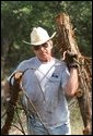 President George W. Bush clears cedar at his ranch in Crawford, Texas, Friday, Aug. 9, 2002. White House photo by Eric Draper.