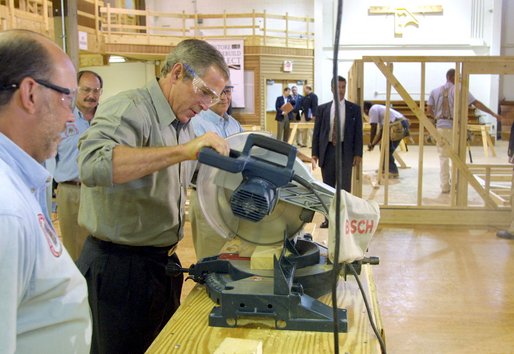 President George W. Bush takes a turn at a table saw during a Labor Day tour of the Carpenters Joint Apprenticeship Center on Neville Island, Pennsylvania. White House photo by Paul Morse.