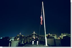 U.S. Marines lower the American flag flying over the White House to half staff at midnight Tuesday, September 10, to mark the anniversary of September 11. Pictured in the background is the Eisenhower Executive Office Building. White House photo by Tina Hager.