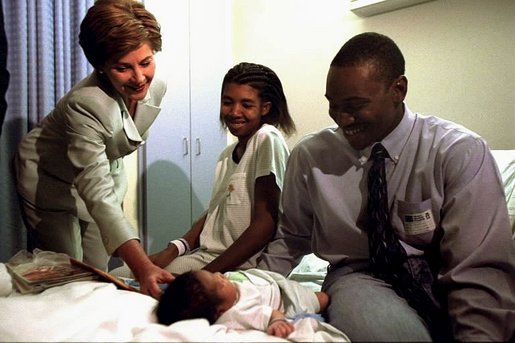 Laura Bush caresses the newborn son of parents in the maternity ward of Tampa General Hospital in Tampa, Fla., Oct. 1, 2002. Mrs. Bush toured the hospital and distributed early-childhood parenting guides form her "Healthy Start, Grow Smart" initiative. White House photo by Susan Sterner.