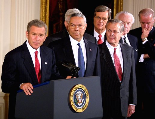 Accompanied by a bipartisan group of legislators, President George W. Bush signed H.J. Resolution 114 authorizing the use of force against Iraq in the East Room Wednesday, Oct. 16. Standing next to the President are Secretary of State Colin Powell, center, and Secretary of Defense Donald Rumsfeld, right. White House photo by Paul Morse.