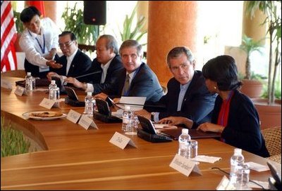 President George W. Bush speaks with National Security Advisor Condoleezza Rice at the start of the group meeting with ASEAN leaders 10th APEC leaders meeting in Los Cabos, Mexico, Saturday, Oct. 26, 2002. Also pictured seated from left are His Majesty Sultan Haji Hassanal Bolkiah Mu'Izzaddin Waddaulah and Pehin Dato Lim Jock Seng both of Brunei and Chief of Staff Andy Card. White House photo by Tina Hager
