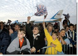 Air Force One stands at the ready for President George W. Bush as a crowd cheers while the aircraft's chief passenger speaks during the Arkansas Welcome at the Northwest Arkansas Regional Airport, Monday, Nov. 4.  White House photo by Eric Draper
