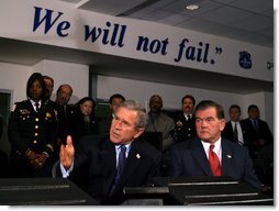 President George W. Bush answers questions from the press during a tour of the District of Columbia's Metropolitan Police Department Synchronized Operations Center, Tuesday, Nov. 12. Homeland Security Advisor Tom Ridge, right, also participated in the tour.   White House photo by Paul Morse
