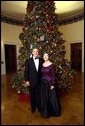 President George W. Bush and Laura Bush stand before the Blue Room Christmas Tree Sunday, December 8, 2002 prior to hosting a reception for the Kennedy Center Honorees. Mrs. Bush is wearing a floor length gown designed by Arnold Scaasi.  White House photo by Eric Draper