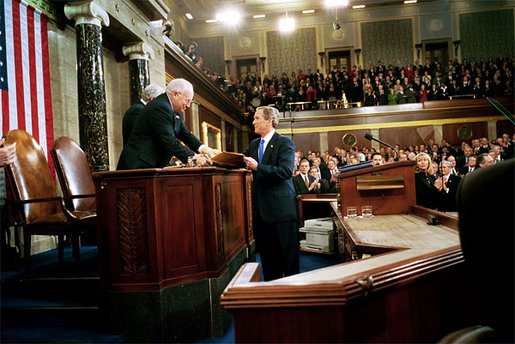 President George W. Bush hands Vice President Dick Cheney and Speaker of the House Dennis Hastert (not pictured) a copy of his State of the Union Address upon his arrival to the House Chamber at the U.S. Capitol Tuesday, Jan. 28, 2003. White House photo by Eric Draper
