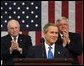 President George W. Bush reacts to applause while delivering the State of the Union address at the U.S. Capitol, Tuesday, Jan. 28, 2002.  Also pictured are Vice President Dick Cheney, left, and Speaker of the House Dennis Hastert. White House photo by Eric Draper