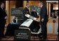President George W. Bush looks over a scooter powered by solid hydrogen fuel during a demonstration of energy technologies at The National Building Museum in Washington, D.C., Thursday, Feb. 6, 2003. "Cars that will run on hydrogen fuel produce only water, not exhaust fumes," said the President in his remarks. "If we develop hydrogen power to its full potential, we can reduce our demand for oil by over 11 million barrels per day by the year 2040." White House photo by Paul Morse