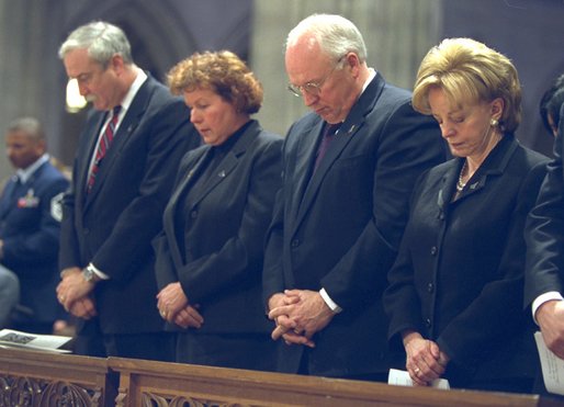 Bowing their heads in prayer, NASA Administrator Sean O'Keefe, far left, Laura O'Keefe, left, Vice President Dick Cheney, center, and Lynne Cheney attend a memorial service for the Space Shuttle Columbia astronauts at the National Cathedral in Washington, D.C., Thursday, Feb. 6, 2003. The seven astronauts died when the space shuttle broke apart upon re-entering the atmosphere Feb. 1, 2003. White House photo by David Bohrer