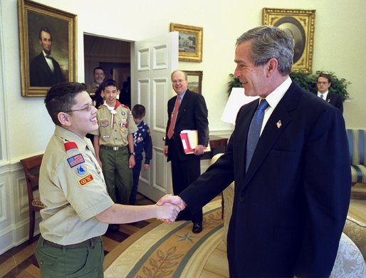 President George W. Bush talks with First Class Scout Zachary Gomez before the presentation of the annual report by the Boy Scouts of America in the Oval Office Tuesday, Feb. 11, 2003. In 1911, President William Howard Taft was the first President to host a visit by the BSA. Every President since then has served as Honorary President of the BSA during his term. White House photo by Eric Draper.