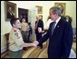 President George W. Bush talks with First Class Scout Zachary Gomez before the presentation of the annual report by the Boy Scouts of America in the Oval Office Tuesday, Feb. 11, 2003. In 1911, President William Howard Taft was the first President to host a visit by the BSA. Every President since then has served as Honorary President of the BSA during his term. White House photo by Eric Draper.