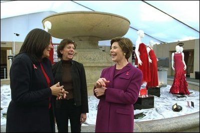 Laura Bush shares a light moment with Fern Mallis of 7th on Sixth, left, and Lynn Long, chief of Fashion Week production, after reviewing the designer dresses on display for "The Red Dress Project" in Bryant Park in New York City Friday, Feb. 14, 2003. "The Red Dress Project" is part of the Heart Truth campaign to raise awareness of heart disease as the number one killer of women. The dresses were created by 19 American designers and will tour for one year and then be auctioned to benefit the American Heart Association. White House photo by Susan Sterner