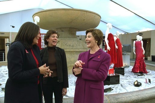 Laura Bush shares a light moment with Fern Mallis of 7th on Sixth, left, and Lynn Long, chief of Fashion Week production, after reviewing the designer dresses on display for "The Red Dress Project" in Bryant Park in New York City Friday, Feb. 14, 2003. "The Red Dress Project" is part of the Heart Truth campaign to raise awareness of heart disease as the number one killer of women. The dresses were created by 19 American designers and will tour for one year and then be auctioned to benefit the American Heart Association. White House photo by Susan Sterner.