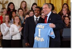 Tony Lawson, captain of the University of California, Los Angeles men's soccer team, presents President George W. Bush with a team jersey during a visit by the NCAA Fall Champions in the East Room Monday, Feb. 24, 2003.  White House photo by Tina Hager