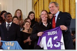Valerie Fletcher, captain of the women's soccer team at University of Portland, gives President George W. Bush a team jersey during a visit by the NCAA Fall Champions in the East Room Monday, Feb. 24, 2003.  White House photo by Tina Hager