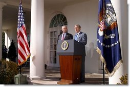 As Secretary of State Colin Powell stands by his side, President George W. Bush addresses the media in the Rose Garden Friday, March 14, 2003.   White House photo by Paul Morse