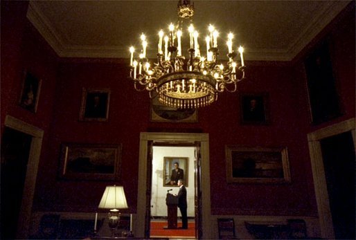 Viewed from the Red Room, President George W. Bush addresses the nation from the Cross Hall in the White House Monday evening, March 17, 2003. White House photo by Eric Draper