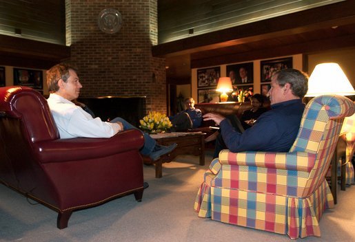 President George W. Bush and British Prime Minister Tony Blair meet, Wednesday night, March 26, 2003 at Camp David. Also pictured in background are Chief of Staff Andy Card and National Security Advisor Condoleezza Rice. White House photo by Eric Draper