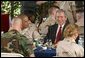 President George W. Bush sits down for lunch with military personnel at MacDill Air Force Base in Tampa, Florida, Wednesday, March 26, 2003.  White House photo by Paul Morse