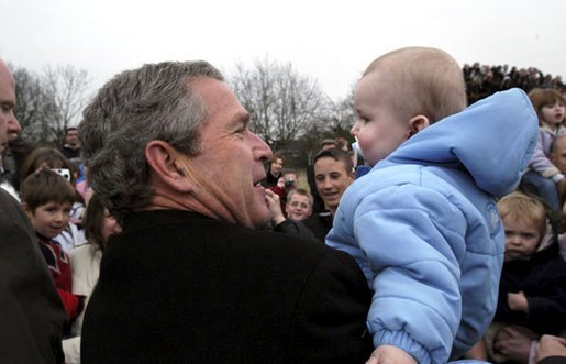 Welcomed by an enthusiastic crowd, President George W. Bush holds a child during an airport arrival greeting at RAF Aldergrove airport in Northern Ireland, Monday, April 7, 2003. White House photo by Eric Draper.