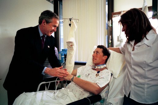 President George W. Bush shakes hands with Army SFC Thomas Douglas of Fayetteville, N.C., after presenting him with the Purple Heart at Walter Reed Army Medical Center in Washington, D.C., Friday, April 11, 2003. Also pictured is Mr. Douglas' wife, Donna Douglas. White House photo by Eric Draper
