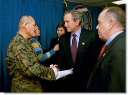 President George W. Bush and Laura Bush attend the U.S. Citizenship Ceremony for Marine Corps Mastery Gunnery Sgt. Guadalupe Denogean of Tucson, Ariz., at the National Naval Medical Center in Bethesda, Md., Friday, April 11, 2003. Pictured at far right, Eduardo Aguirre, Jr., Acting Director of the Bureau of Citizenship and Immigration Services, conducted the ceremony.  White House photo by Eric Draper
