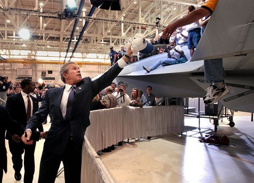 President George W. Bush reaches for a cap to sign after speaking at the Boeing F-18 Production Facility in St. Louis, Mo., Wednesday, April 16, 2003. White House photo by Eric Draper