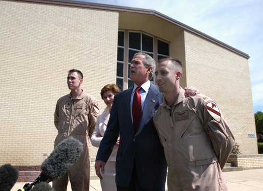 President George W. Bush puts his arm around Chief Warrant Officer David S. Williams as he speaks to the media with Chief Warrant Officer Ronald D. Young Jr., left, and Mrs. Bush after attending Easter church services at the 4th Infantry Division Memorial Chapel at Fort Hood, Sunday, April 20, 2003. Williams and Young are former POW's. White House photo by Eric Draper.