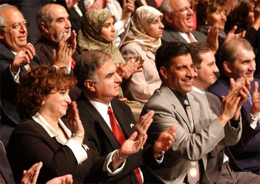 Standing at the far right, Haider Al-Jebori, President of the Steering Committee for Iraqi Home Culture, applauds for President George W. Bush at the Ford Community and Performing Arts Center in Dearborn, Mich., Monday, April 28, 2003. White House photo by Tina Hager.
