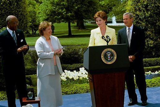 Laura Bush introduces the President George W. Bush during a ceremony honoring National Teacher of the Year Betsy Rogers, left, as Secretary of Education Rod Paige looks on at the White House April 30, 2003. White House photo by Susan Sterner